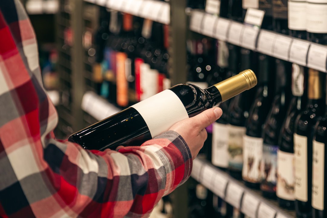 Botellas de bebidas alcohólicas en góndola de supermercado