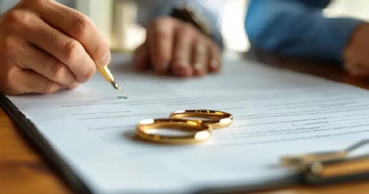 Pareja firmando documentos de divorcio en un juzgado de Familia
