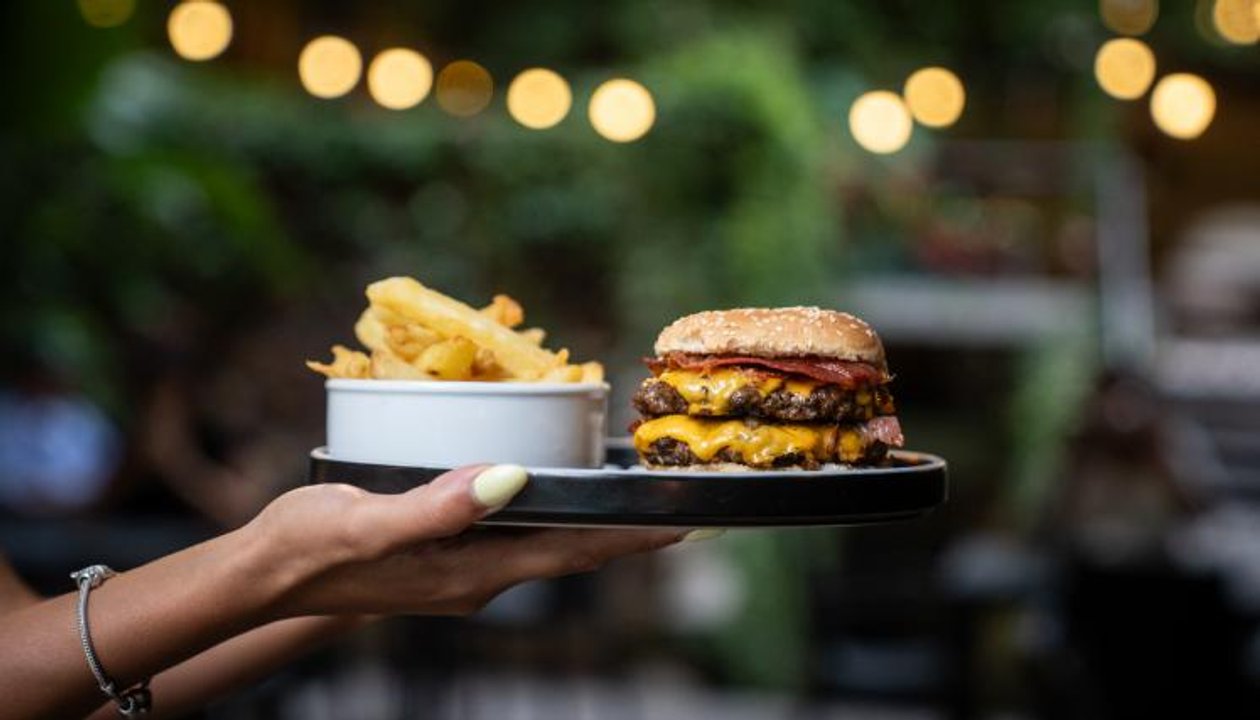 Personas disfrutando hamburguesas en una propuesta gastronómica porteña
