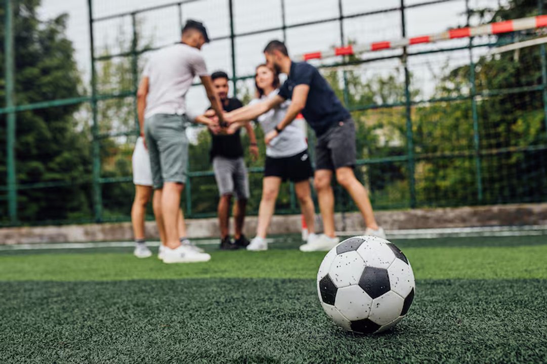 Jugadores de fútbol amateur disputando una pelota en la cancha