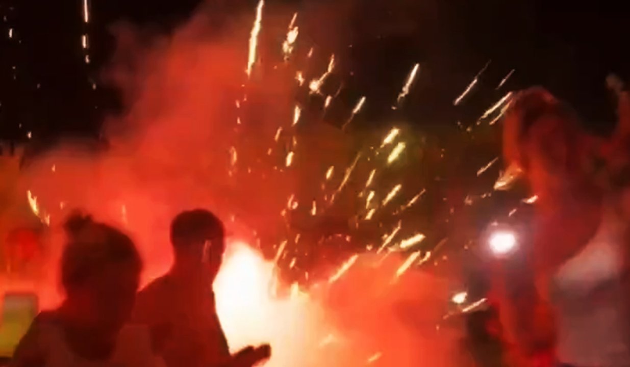 Hinchas españoles intentando quemar una bandera argentina con pirotecnia